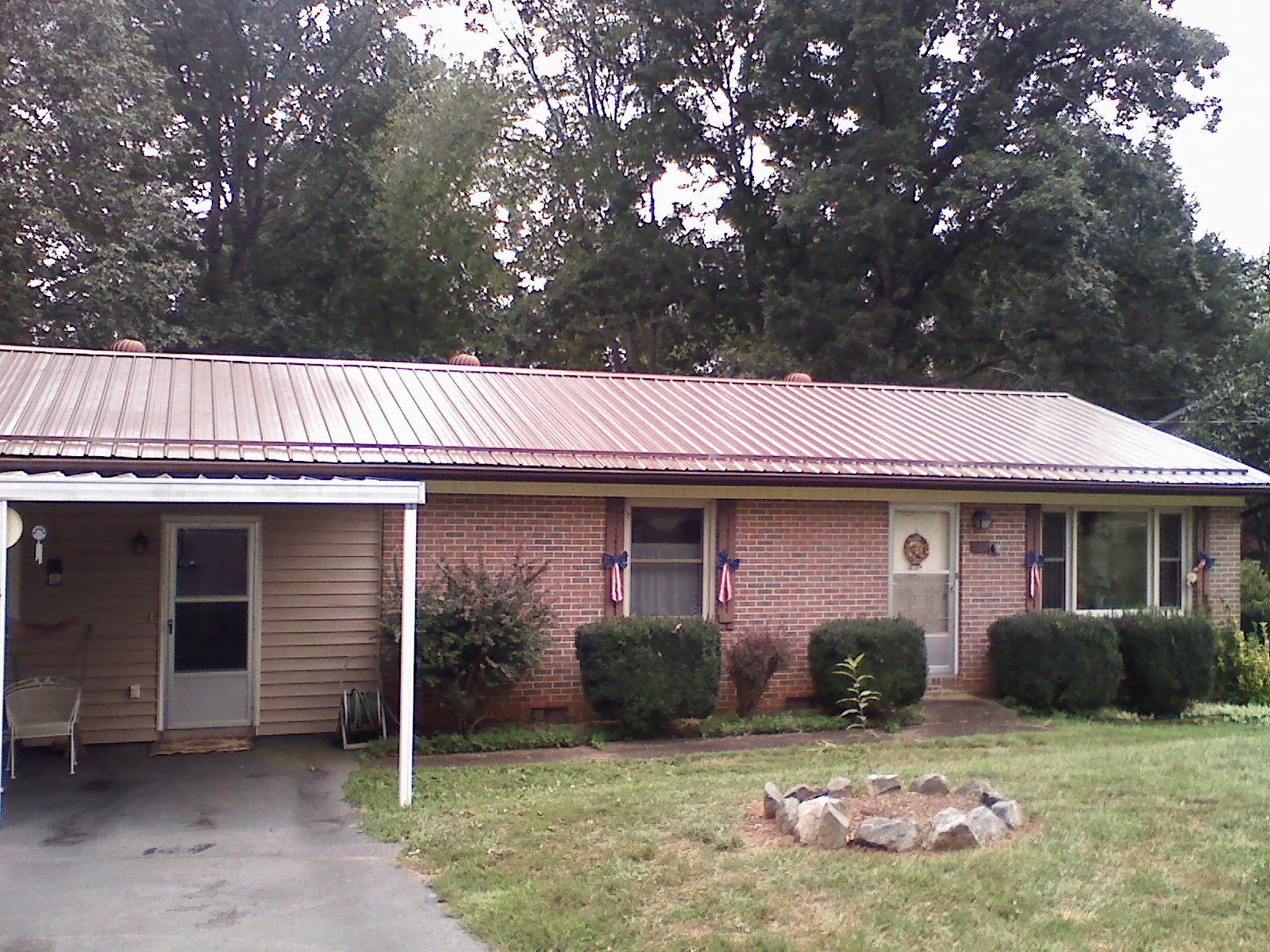 Bronze metal roof and carport on a brick ranch home — Roof Repair work by our crew in Spring Creek